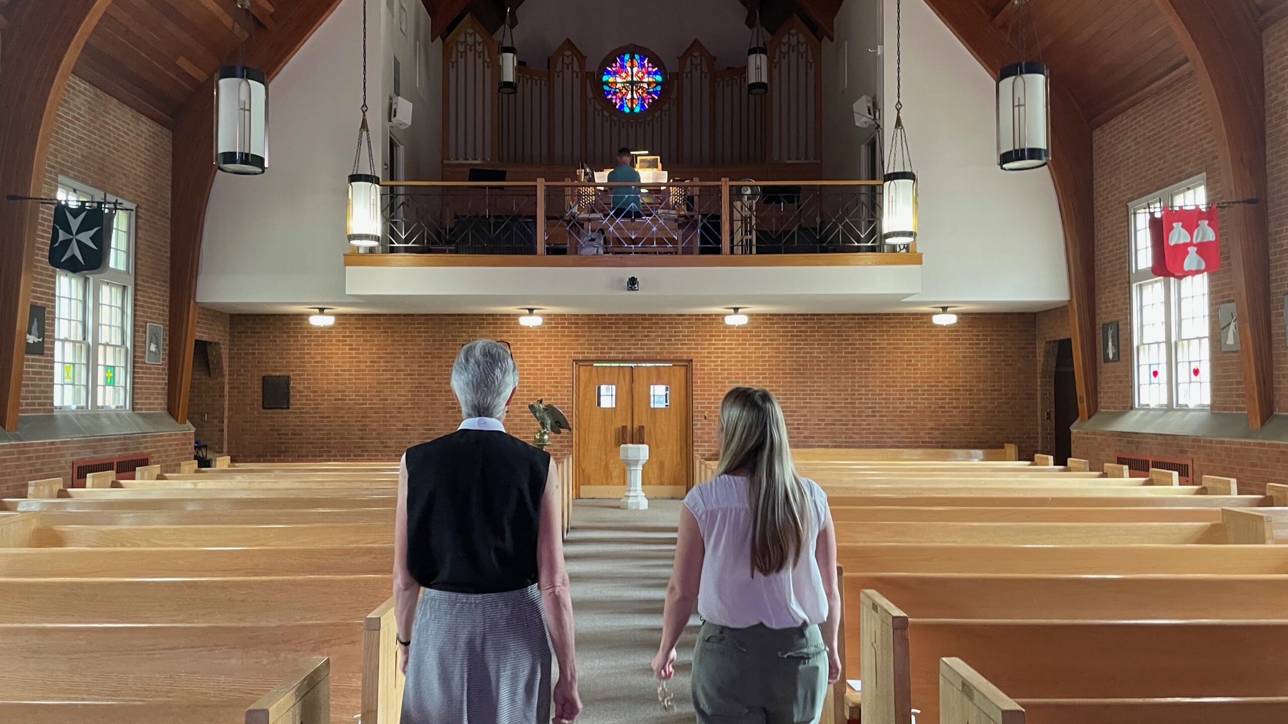 Rev. Maria Tjeltveit and Jessica Entwistle walk through the pews of the Church of the Mediator in Allentown, Pennsylvania. (Photo by Kabir Burman.)