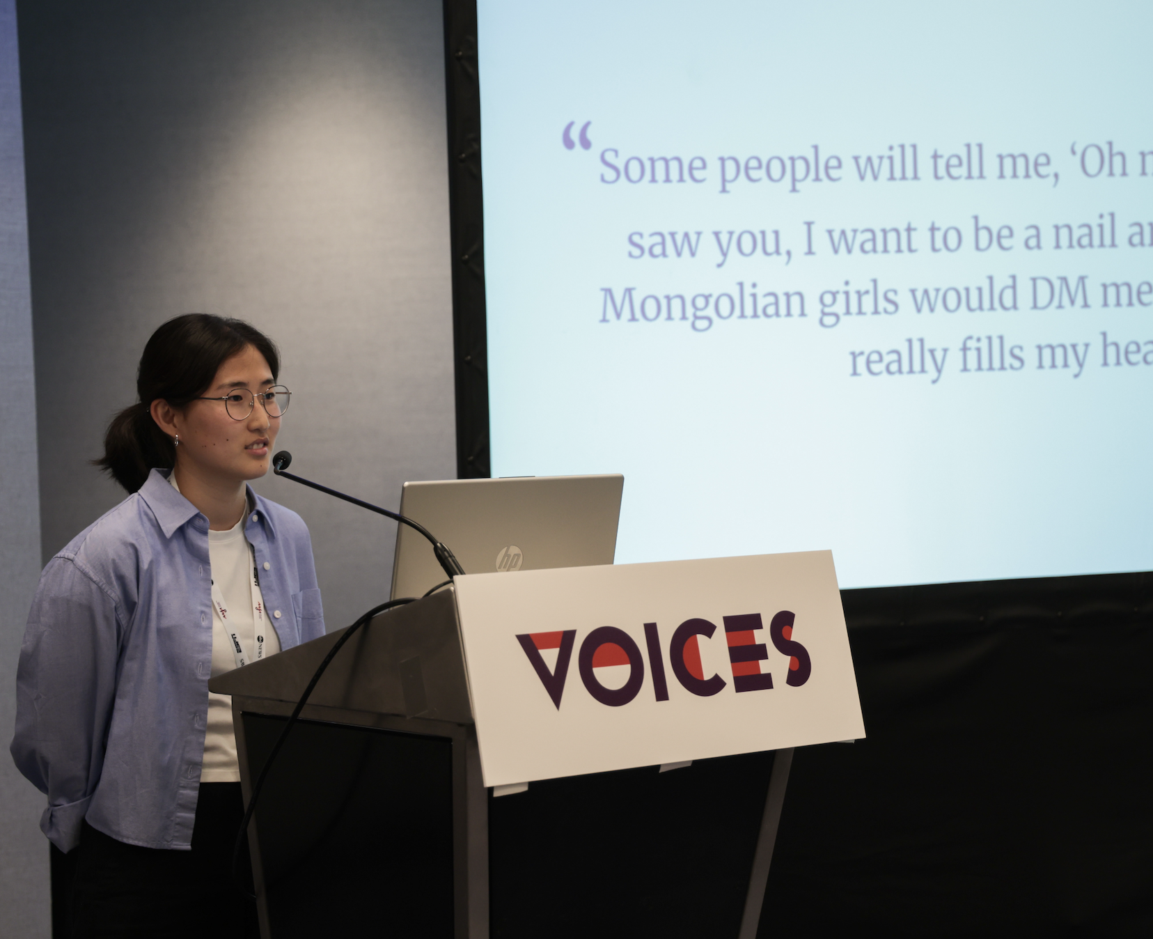 Photo of Voices fellow standing against AAJA backdrop onstage